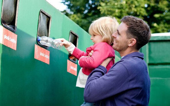 Mann und Kind recyceln eine Flasche