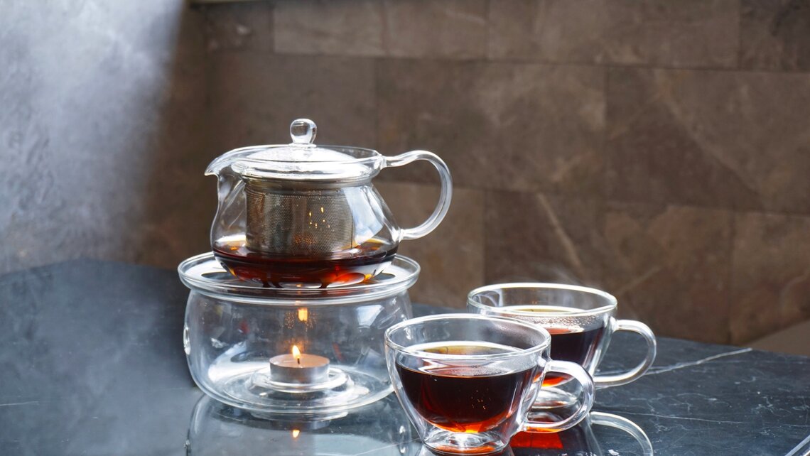 Tea glasses with glass teapot on warmer