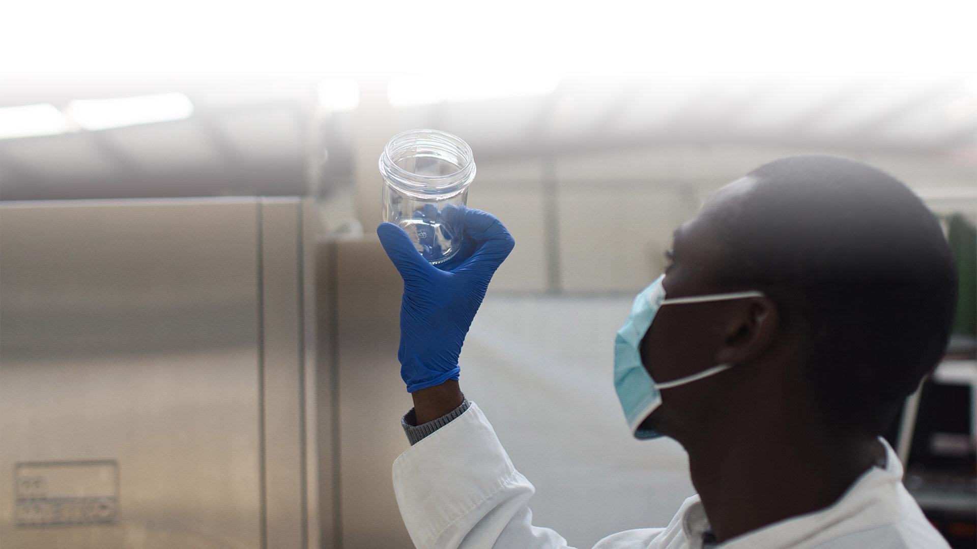 Man holding up a returnable glass